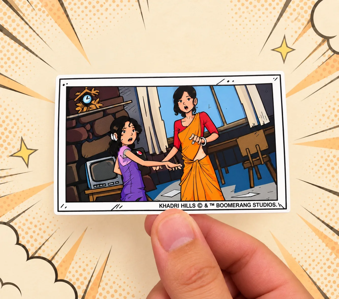 A hand holding a Khadri Hills UV sticker of a comic scene, cut with a white border